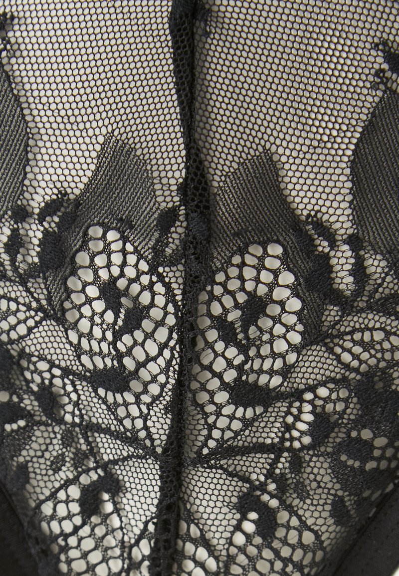 Body in pizzo nero con motivi floreali intricati, design in rete e una base in tessuto morbido. Dettagli di texturizzazione lungo i bordi.