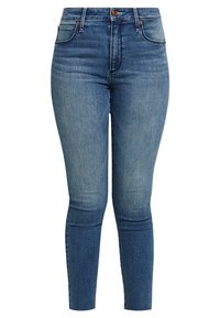 Jeans ajustados de mezclilla azul con cintura alta, diseño de cinco bolsillos y un ligero desgaste. Presenta botones metálicos y detalles de costura.