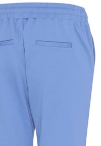 Hele sinised elastse vöökohaga püksid, millel on kaks tagumist lipsutaskut ja sileda kangapinnaga tekstuur.