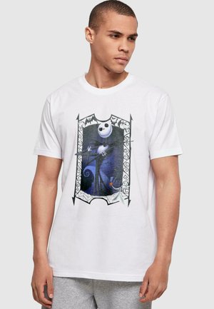 Hvid bomulds T-shirt med et grafisk print af en karakter inden for en dekorativ ramme, med sorte konturer og farverige detaljer.