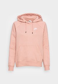 Ljusrosa hoodie i mjukt tyg. Har en kenguruficka, dragsko och en vit Nike-logotyp på bröstet. Raglansleeves.