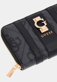 Portafoglio in faux pelle nera con superfici texturizzate, strisce orizzontali, un accento logo dorato e una chiusura con zip dorata con dettagli del marchio.