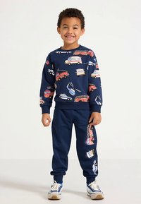 Navyblaues Kinder-Sweatshirt- und Hosen-Set mit bunten Fahrzeugmotiven. Weicher Stoff, gerippte Bündchen und Taille, lässige Passform.