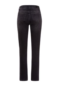 Svarta raka denimjeans med bakfickor och bälteshällor, visade bakifrån på en vit bakgrund.