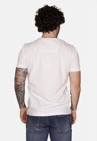 T-shirt bianca a maniche corte realizzata in cotone; presenta una vestibilità classica con scollatura rotonda e un piccolo logo dettagliato in basso.