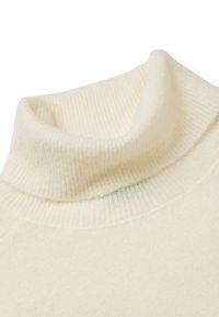 Cremefarbener Rollkragenpullover aus weichem, geripptem Stoff mit umgeschlagenem Kragen und nahtlosem Schulterdesign.