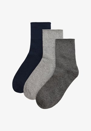 Tres calcetines lisos hasta la altura de la tripulación en azul marino, gris claro y gris oscuro, dispuestos uno al lado del otro sobre un fondo blanco.