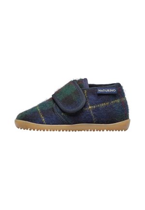 Pantofole in feltro di colore blu scuro con un motivo a quadri verde e giallo, dotate di un ampio cinturino in Velcro, punta arrotondata e suola in gomma testurizzata.