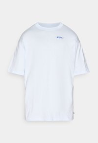 Hvid kortærmet t-shirt lavet af bomuld, med et blåt "INTER" logo og Nike swoosh på venstre bryst. Enkel og afslappet design.