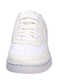 Sneaker in pelle bianca con punta forata, lacci piatti e suola in gomma grigia. Presenta un design cucito e un sottile dettaglio del logo.