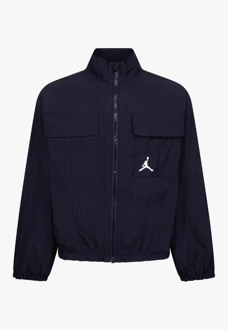 Giacca zip-up blu navy realizzata in materiale leggero, con due tasche frontali e un logo Jordan bianco sul lato sinistro.