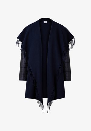 Námořnický pončo s třásněmi na spodním lemu, vyrobené z měkkého materiálu. Obsahuje prošívané černé rukávy pro zvýšení tepla a kontrast textur.