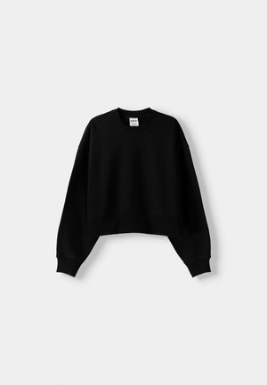 Sweatshirt negru, scurt, cu guler rotund, mâneci lungi și manșete côtelate. Fabricat dintr-un material moale și texturat. Design simplu, fără ornamente.