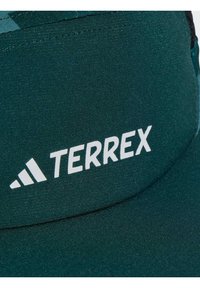 Sötétzöld sapka texturált anyagból, fehér "TERREX" logóval és három csíkos díszítéssel. Ívelt napellenző a árnyékért.