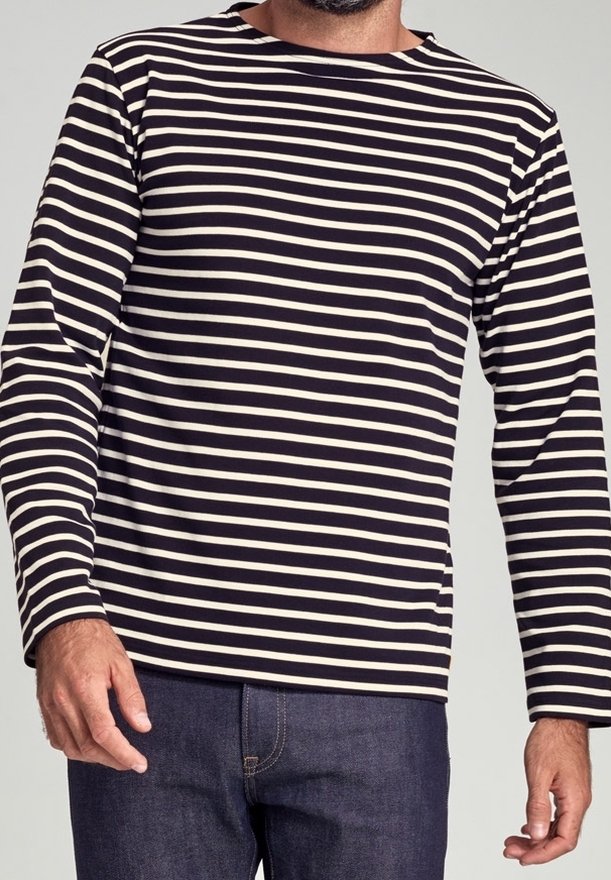 Randig långärmad tröja med marinblå och krämfärgade horisontella ränder, rund halsringning och en avslappnad passform. Tyget verkar mjukt och lätt.
