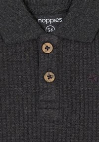 Donkergrijze polo met een geribbelde textuur, voorzien van een kraag en twee knoopsluitingen; inclusief een klein geborduurd logo. Maatlabel zichtbaar.