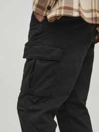 Schwarze Cargo-Hosen mit mehreren Seitentaschen, aus einem glatten Stoff gefertigt. Sie verfügen über einen lässigen Schnitt und sichtbare Nähdetails.