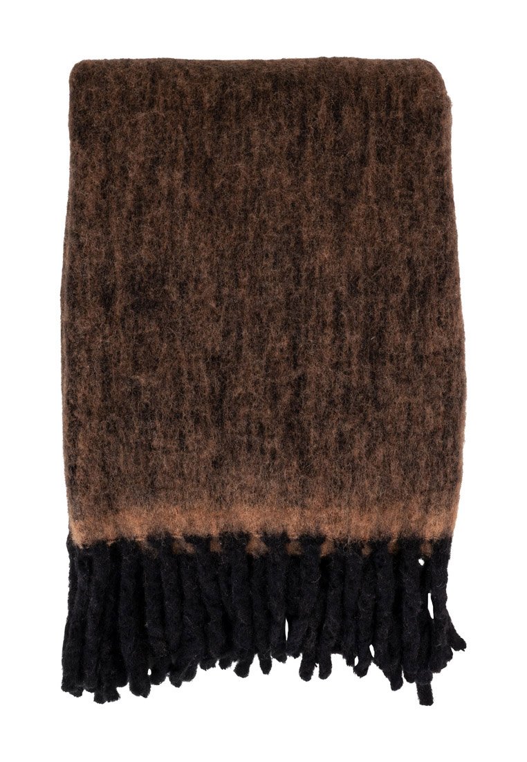 Coperta intrecciata marrone con una superficie morbida e testurizzata, caratterizzata da frange nere lungo il bordo inferiore e un effetto sfumato.