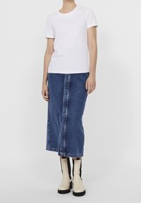 Vit bomull t-shirt, kort ärm; blå denimkjol, knälång med framsöm; krämfärgade ankelboots med svarta sidosträck.