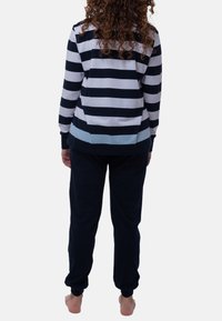 Långärmad randig topp i marinblått och ljusgrått, tillsammans med mörkblå byxor, med en avslappnad passform och mjukt bomullsmaterial.