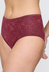 Bordowe damskie majtki z koronki w kwiatowy wzór, z gładką tasiemką w pasie i bezszwowymi bokami, zapewniającymi eleganckie dopasowanie.