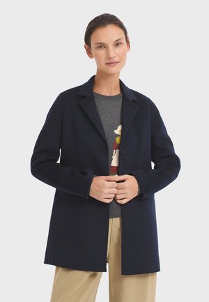 Navy wool coat with a notched collar, single button closure, and two front pockets. Slim fit, mid-length design, soft texture.