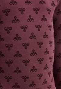 Mörkröd textil med ett upprepat mönster av bin i mörkbrunt. Materialet verkar mjukt, med en jämn yta och en tät väv.