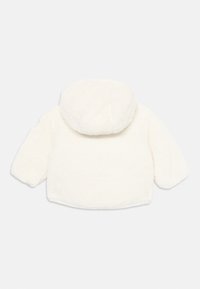 Vit fleecejacka med huva, med ett mjukt, strukturerat tyg och långa ärmar. Enkel design utan synliga knäppningar eller detaljer.