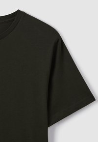 T-shirt in cotone verde scuro a maniche corte con collo rotondo, mostrata su uno sfondo grigio chiaro.