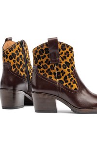 Bottines en cuir brun avec un dessus en textile à motif léopard, fermeture éclair sur le côté et talon empilé. Le design comprend une languette pour un enfilage facile.