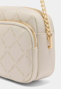Beige kožená crossbody taška s embosovaným vzorem loga, zlatě tónovaný řetězový popruh a zipové uzavření. Texturovaný povrch s elegantním designem.