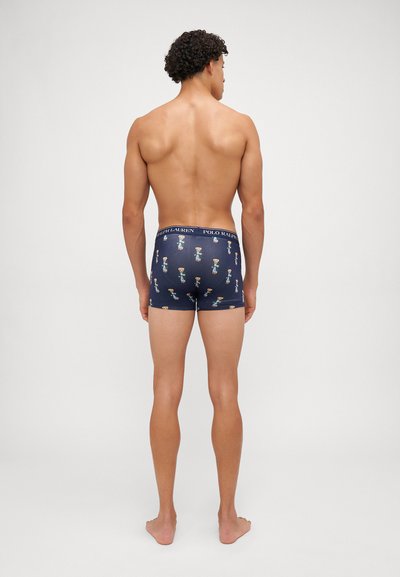 Boxers de cor navy com faixa elástica, apresentando um padrão repetido de personagens de cartoon; tecido suave com um ajuste justo e costuras mínimas.