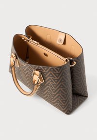 Sac à main à motif marron avec quincaillerie dorée, anses en cuir lisse et intérieur ouvert comportant une poche zippée.