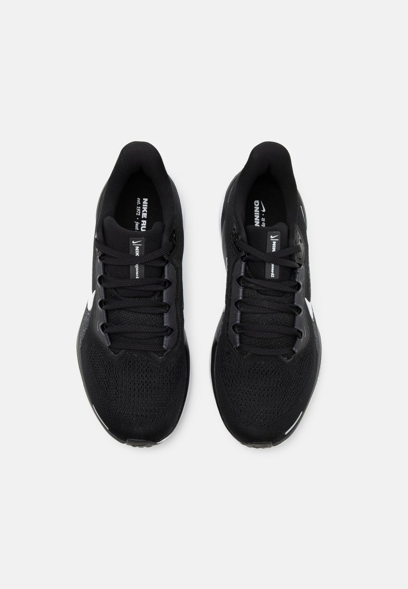 Zapatillas deportivas negras con parte superior de malla transpirable, cordones planos y marca blanca. Cuenta con una suela acolchada y un diseño ligero.