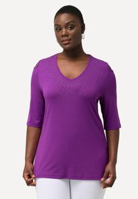 Paars V-hals T-shirt met korte mouwen, met open schouders en versierd met strass-steentjes in een verlooppatroon.