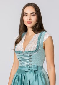 Light blue dirndl dress with lace trim, fitted bodice, and decorative lacing. Features a satin waist ribbon and flared skirt.