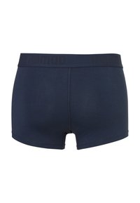 Marineblaue Boxershorts aus weichem Material mit einem breiten elastischen Bund, der den Markennamen "nomad" in schwarzer Schrift trägt.