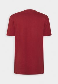 Rotes T-Shirt mit kurzen Ärmeln aus weicher Baumwolle, versehen mit einem Rundhalsausschnitt und einem schlichten Rückendesign ohne Logos oder Verzierungen.