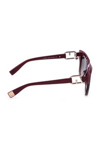 Lunettes de soleil rectangulaires rouge foncé avec des charnières en métal doré et des verres dégradés, montrées de côté sur un fond blanc.