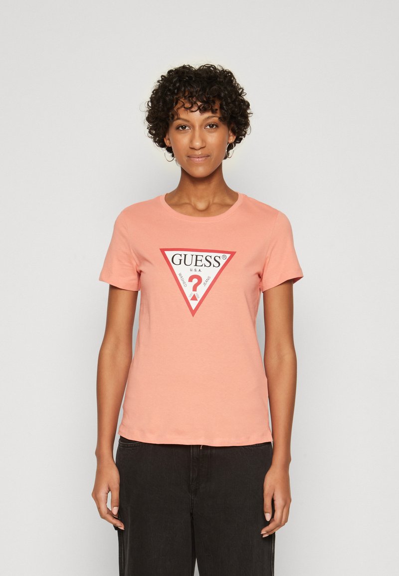 Pink bomulds t-shirt med rund halsudskæring og korte ærmer, med en rød trekantet grafik, hvor der står "GUESS" og et spørgsmålstegn i midten.