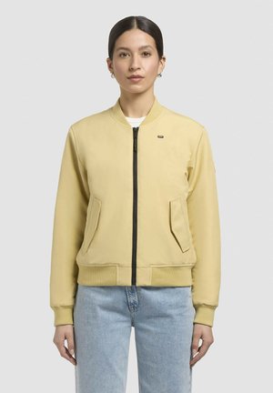 Heled kollane bomber-jakk, millel on lukuga sulgemine, küljetaskud, soonikkoes varrukad ja serv, ning vasakul rinna kohal väike logo.