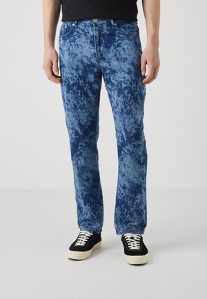 Blå jeans med en sprutet, tie-dye tekstur. Rett ben-design, klassisk femlommestil, parret med sorte og hvide sneakers.