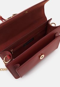 Borsa a tracolla in ecopelle rossa con chiusura a bottone dorato, tracolla a catena e tasca interna con zip. Texture liscia con scomparti divisi per un'ottima organizzazione.