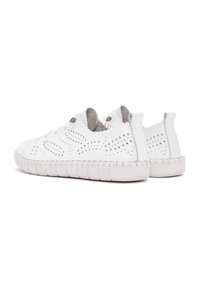 Baskets blanches perforées en cuir, dotées d'une semelle en caoutchouc texturé, de lacets élastiques et d'une doublure intérieure gris discret.