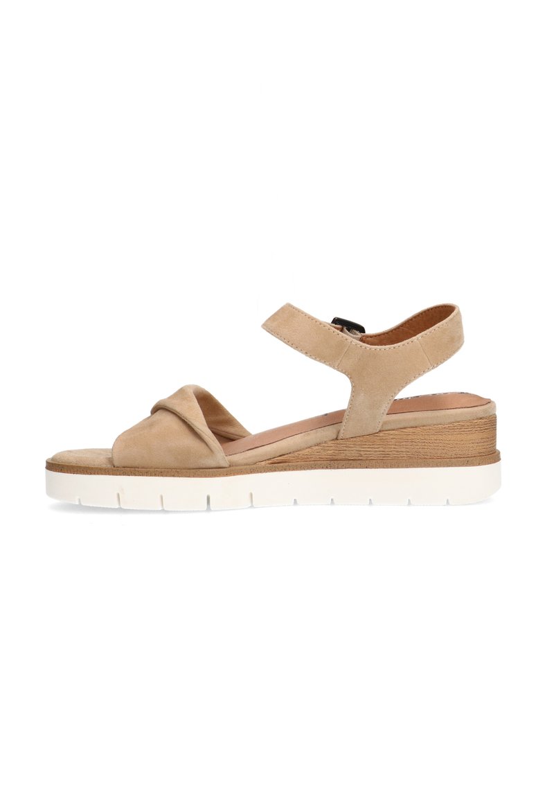Beige suède wedge sandalen met een knoopdetail, verstelbare enkelband en een witte rubberen zool met een houtachtige laag.