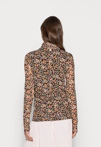 Top floreale a maniche lunghe con sfondo nero, caratterizzato da un motivo di piccoli fiori rosa, gialli e bianchi, realizzato in materiale leggero.