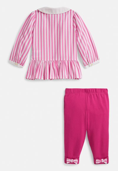 Ροζ και λευκή ριγέ μακρυμάνικη μπλούζα με βολάν στη μέση, σε συνδυασμό με μονόχρωμο ροζ παντελόνι με φιόγκους στα μανσέτα. Ελαφρύ βαμβακερό υλικό.