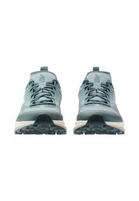 Ζευγάρι αθλητικών παπουτσιών σε τυρκουάζ χρώμα με κορδόνια, στραμμένα προς τα εμπρός, σε λευκό φόντο, που δείχνει τις υφασμάτινες σόλες και το λογότυπο στη γλώσσα και στην περιοχή της μύτης.