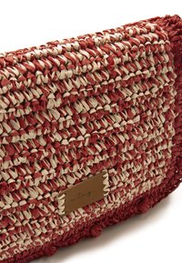 Borsa a spalla intrecciata in rosso e crema, con un design testurizzato e una forma rettangolare. Include un'etichetta in pelle con lettering impresso.