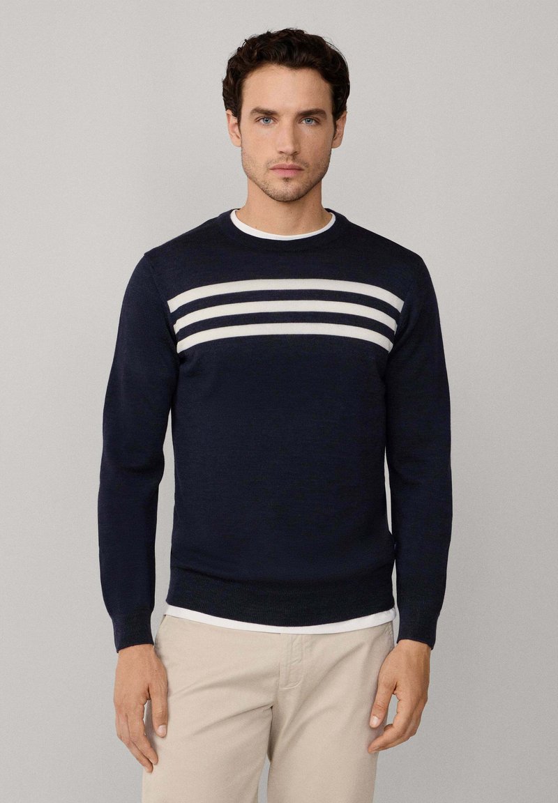 Maglione blu navy realizzato in tessuto a maglia, con strisce orizzontali bianche sul petto, scollo rotondo e design slim fit.